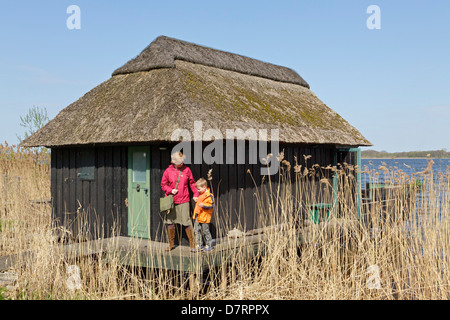 Mère et son fils à côté d'un garage à bateaux au bord de l'eau, Schaalsee Lenschow, Schleswig-Holstein, Allemagne Banque D'Images