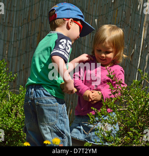 Petit garçon de 4 ans et 2 ans, fille, jouant sur l'arrière-cour Banque D'Images