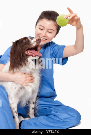 Portrait de femme tenant un vétérinaire balle avec un chien Banque D'Images