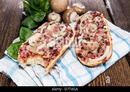 Pizza aux champignons et au jambon Baguette sur fond de bois Banque D'Images