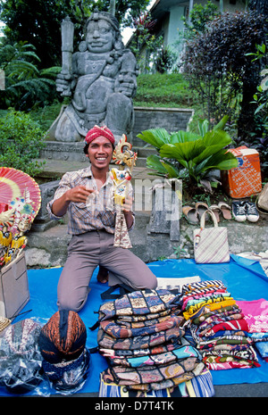 Un vendeur de souvenirs et d'artisanat divers montre ses marchandises à des touristes près de Semarang sur l'île de Java en Indonésie en Asie du sud-est. Banque D'Images