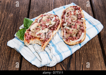 Pizza aux champignons et au jambon Baguette sur fond de bois Banque D'Images