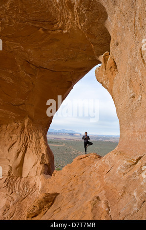 Guide d'escalade avec Moab désert, n'yoga sur Looking Glass Rock, près de Moab, Utah. (MR) Banque D'Images