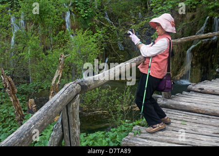 Femme touriste prenant des photos des cascades et des lacs du parc national des lacs de Plitvice, un site du patrimoine mondial de l'UNESCO, en Croatie en mai Banque D'Images