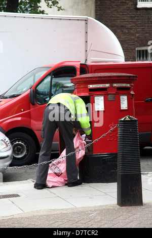 Facteur britannique la collecte le courrier d'une boîte à lettres, à Paddington, Londres, mai 2013 Banque D'Images