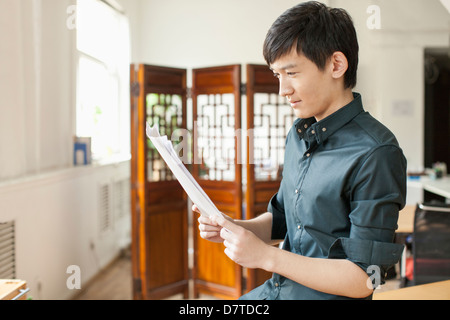 Homme professionnel de regarder des papiers in Office Banque D'Images