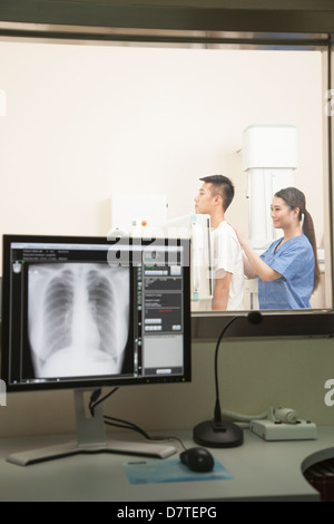 Female Doctor Examining Patient's Mid Section avec machine à rayons X Banque D'Images