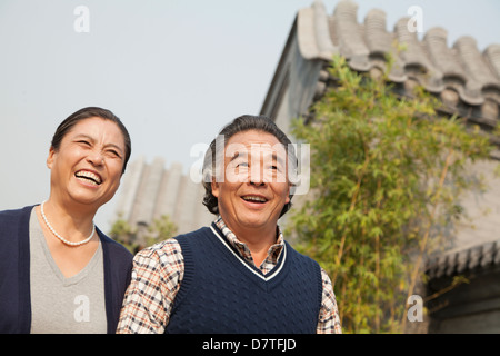 Happy senior couple walking outdoors par bâtiment traditionnel à Beijing Banque D'Images