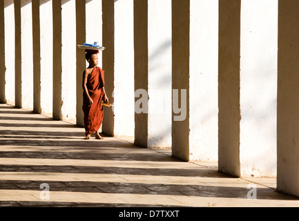 Moine Bouddhiste Novice debout dans l'ombre de colonnes à Shwezigon Paya, Nyaung U, Bagan, Birmanie Banque D'Images