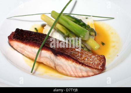 Délicieux poisson cuit au four avec du riz blanc et vert les asperges sur une assiette blanche, un régime alimentaire, santé Banque D'Images