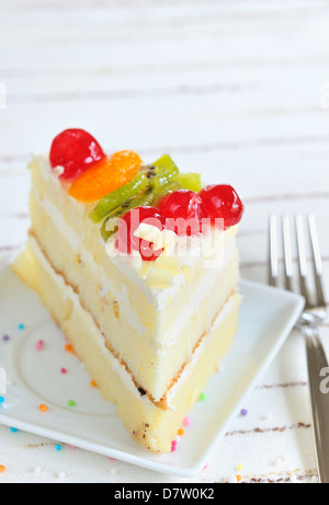 Morceau de gâteau délicieux sur fond blanc Banque D'Images
