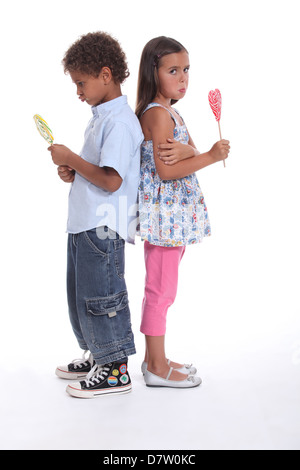 Un petit garçon et une petite fille faisant la moue et eating ice cream Banque D'Images