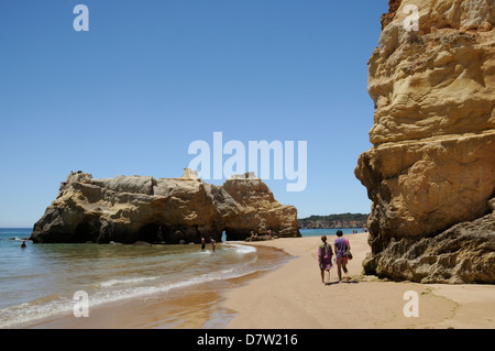 Les gens qui marchent et canot près de falaises de grès et de roches au Praia da Rocha, Portimao, Algarve, Portugal Banque D'Images