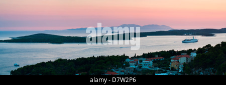 Les îles Pakleni et l''île de Vis, un navire de croisière amarré au coucher du soleil, vu de l'île de Hvar, île de la côte dalmate, Mer Adriatique, Croatie Banque D'Images