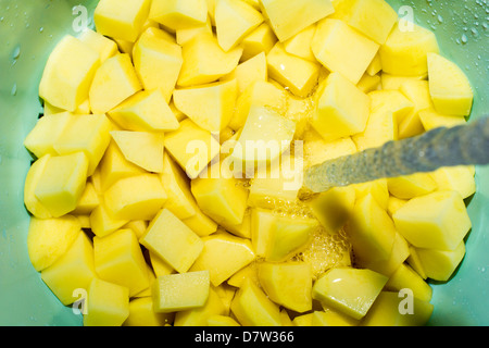 Couper les pommes de terre lavées. Banque D'Images