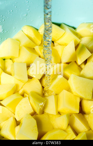 Couper les pommes de terre lavées. Banque D'Images