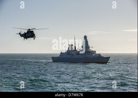 Sea King de la Royal Navy Mk4 flying passé Type 45 destroyer HMS Diamond en mer Banque D'Images