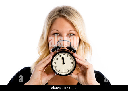 Blond woman holding une horloge pour signifier la fertilité / horloge biologique pour les femmes concept Banque D'Images