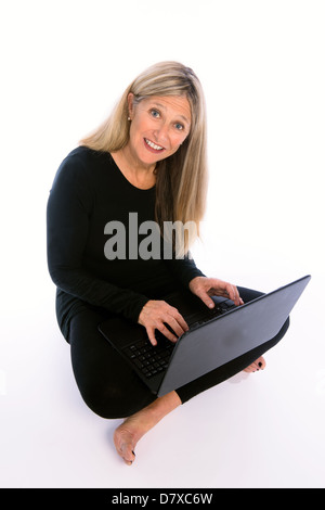 Senior woman using laptop isolées sur fond blanc Banque D'Images