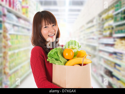 Beautiful Young Asian woman shopping dans une épicerie/supermarché . Banque D'Images