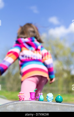 Fillette de six ans a jouer dehors avec des figurines Banque D'Images