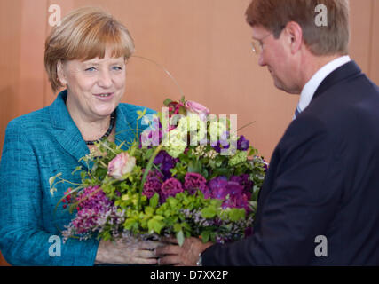 Berlin, Allemagne, le 15 mai 2013. La chancelière allemande Angela Merkel reçoit des fleurs par la chancellerie chef de cabinet Ronald Díaz avant la réunion du Conseil des ministres à la chancellerie à Berlin, Allemagne, le 15 mai 2013. Photo : KAY NIETFELD/DPA/Alamy Live News Banque D'Images