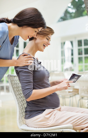 Pregnant woman showing friend sonogram Banque D'Images