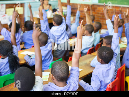 Des élèves en classe les mains Banque D'Images