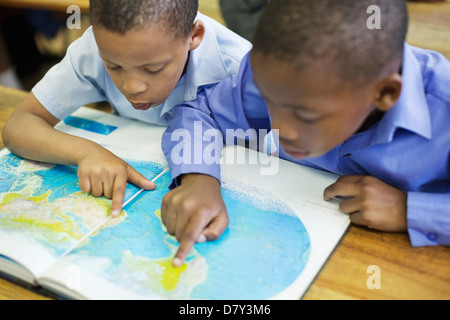 Les élèves à l'aide de la carte du monde en classe Banque D'Images