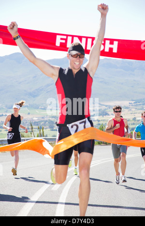Runner crossing race finish line Banque D'Images