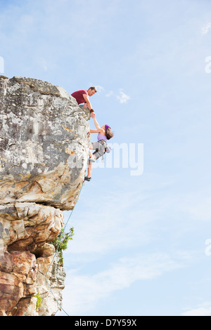 Les grimpeurs scaling steep rock face Banque D'Images
