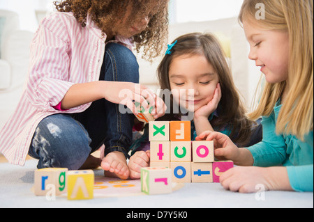 Les filles jouant avec des blocs colorés dans la salle de séjour Banque D'Images