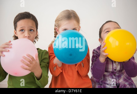 Girls blowing balloons ensemble Banque D'Images