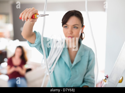 Female electrician de couper les fils dans la maison Banque D'Images