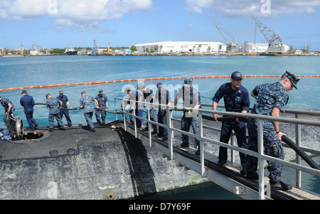 Les marins de l'USS Albuquerque place shore power cables à Guam. Banque D'Images