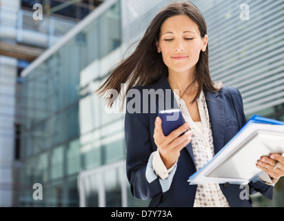 Businesswoman using cell phone in office Banque D'Images