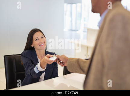 Les gens d'affaires échangeant des cartes in office Banque D'Images