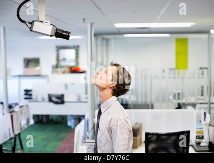 Businessman examining caméra de sécurité dans office Banque D'Images