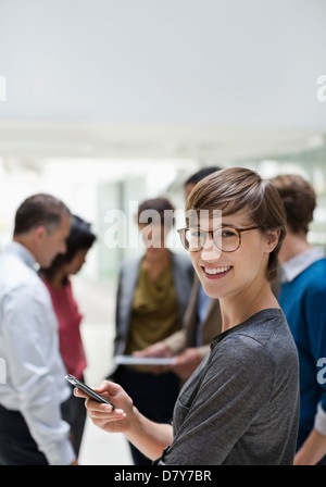 Businesswoman using cell phone in meeting Banque D'Images