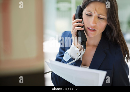 Businesswoman talking on phone in office Banque D'Images