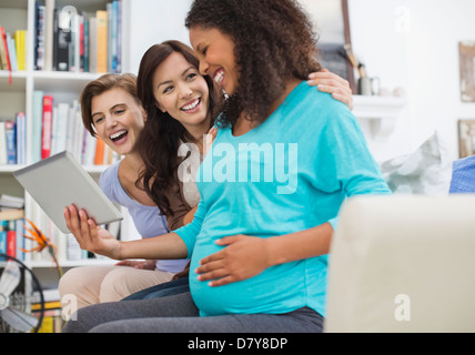 Pregnant woman using tablet computer with friends Banque D'Images