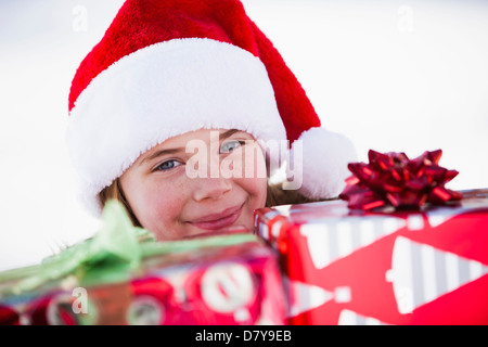 Caucasian boy in Santa hat holding Christmas presents Banque D'Images