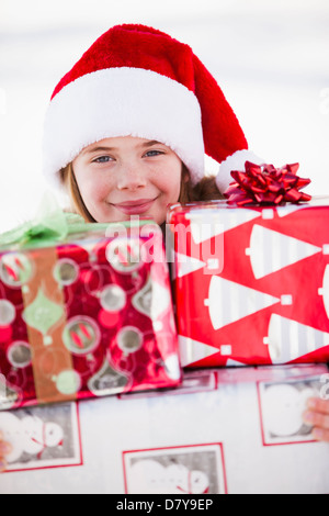 Caucasian boy in Santa hat holding Christmas presents Banque D'Images