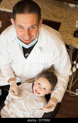 Caucasian dentist examinant les dents du garçon in office Banque D'Images