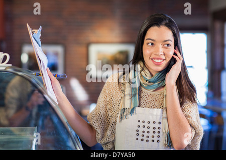 Mixed Race woman working in coffee shop Banque D'Images