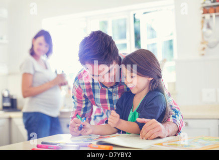 Père fille aidant à utiliser Coloring Book Banque D'Images