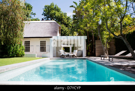 Des chaises de jardin et piscine dans jardin Banque D'Images