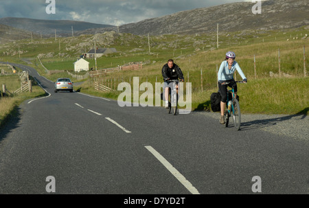 Deux cyclistes équitation vers Leverburgh sur l'île de Harris, Hébrides extérieures, en Écosse Banque D'Images