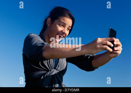 Hispanic teenage girl taking picture Banque D'Images