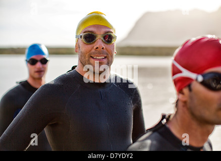 Les triathlètes dans la combinaison de l'eau en souriant Banque D'Images